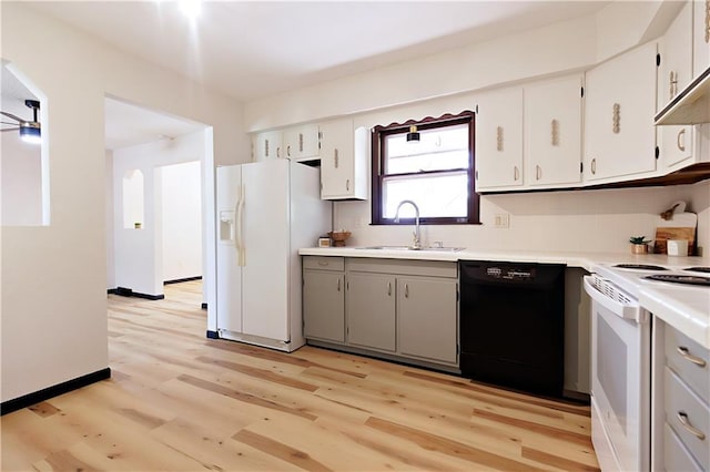 kitchen with sink, white appliances, white cabinets, and light wood-type flooring