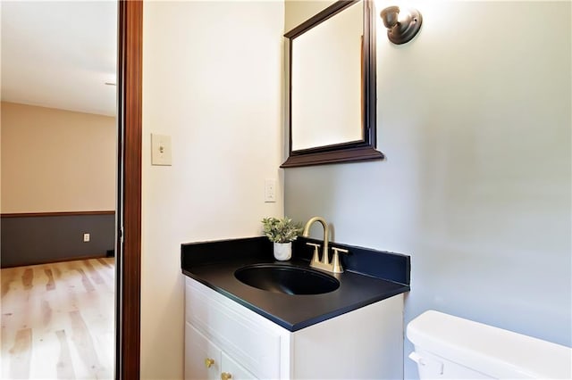 bathroom featuring toilet, hardwood / wood-style floors, and vanity