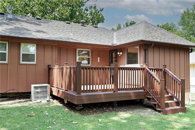 rear view of house with a deck, cooling unit, and a yard