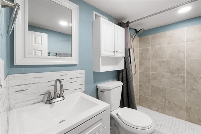 bathroom with tasteful backsplash, vanity, tiled shower, and toilet