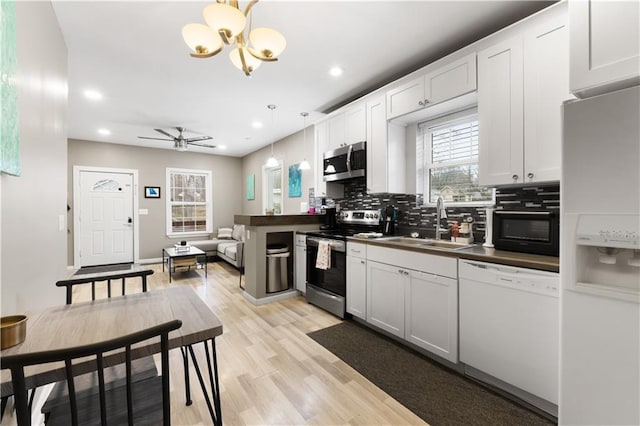 kitchen featuring appliances with stainless steel finishes, pendant lighting, and white cabinets