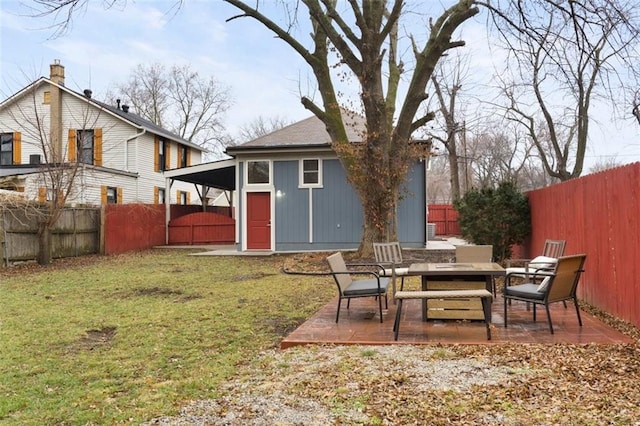 rear view of house with an outdoor structure, a patio, and a lawn