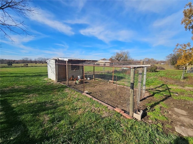 view of yard featuring an outbuilding, a rural view, and exterior structure