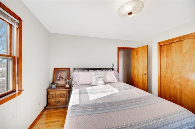 bedroom with light wood-style floors and baseboards