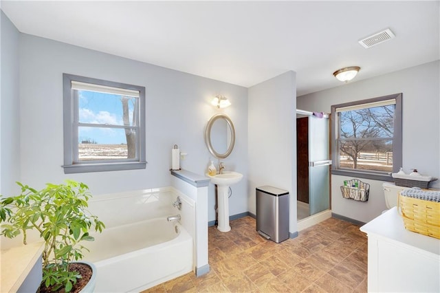 bathroom featuring visible vents, a shower stall, baseboards, and a garden tub