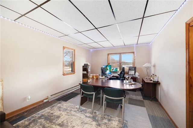 office area featuring a drop ceiling, baseboards, and baseboard heating