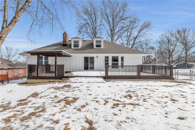 snow covered house featuring a wooden deck