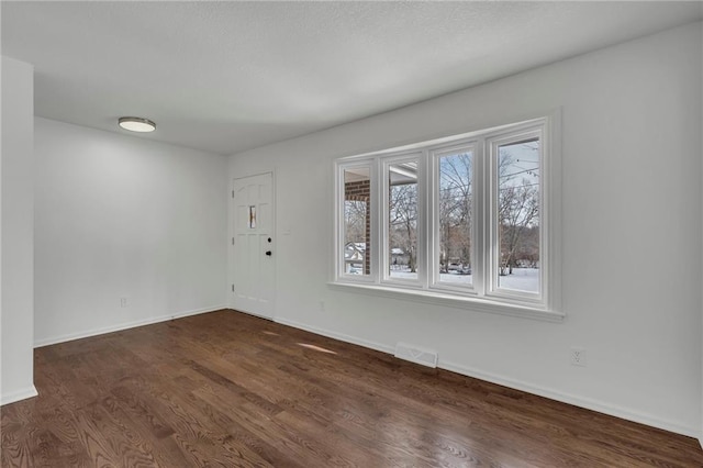 empty room with dark hardwood / wood-style flooring