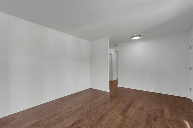 spare room featuring dark wood-type flooring