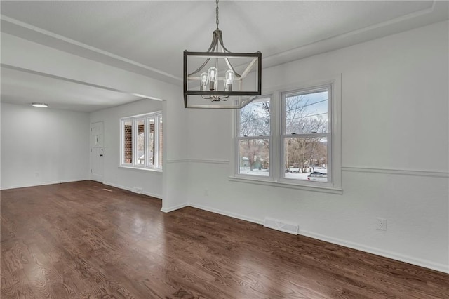 unfurnished dining area with an inviting chandelier and dark hardwood / wood-style flooring