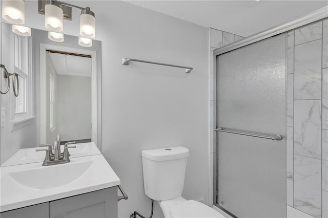 bathroom with a shower with door, vanity, and toilet