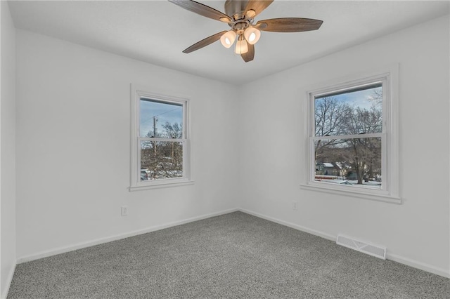 carpeted spare room featuring ceiling fan