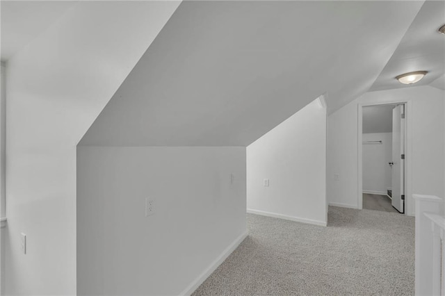 bonus room featuring vaulted ceiling and light carpet