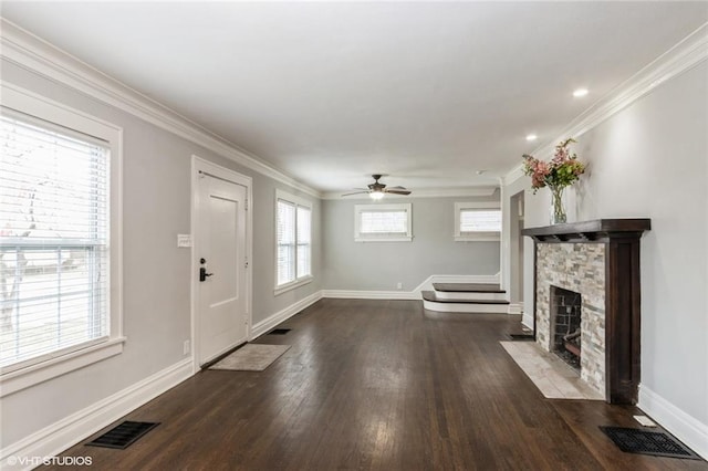 unfurnished living room with a stone fireplace, ornamental molding, and visible vents