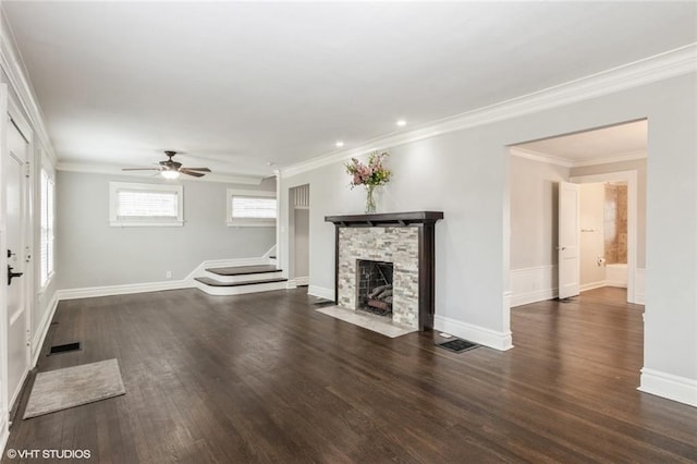 unfurnished living room with dark wood finished floors, a fireplace, visible vents, ornamental molding, and stairs