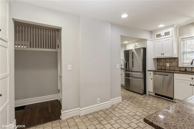 kitchen with glass insert cabinets, white cabinetry, appliances with stainless steel finishes, and a sink