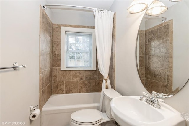 bathroom with shower / bath combo, a sink, and toilet