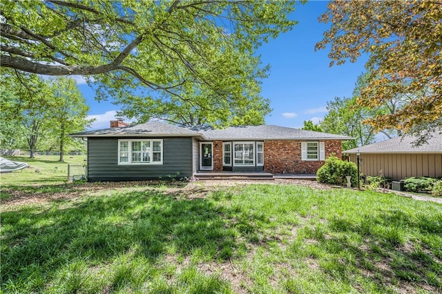 10609 NW Meadow Lane Dr, Parkville, MO 64152 - back of property with a chimney, a yard, and brick siding