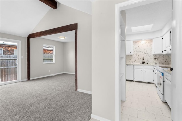 kitchen featuring white appliances, white cabinets, light colored carpet, and backsplash