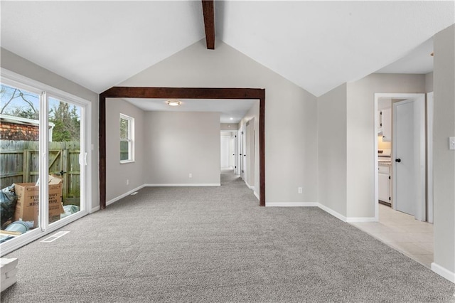 carpeted empty room with vaulted ceiling with beams