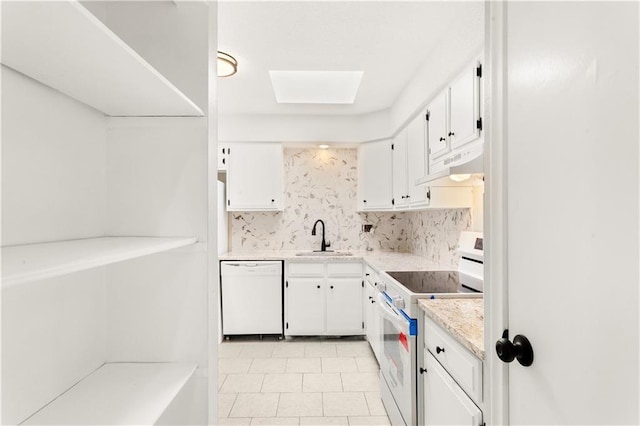 kitchen featuring a skylight, sink, backsplash, white cabinets, and white appliances