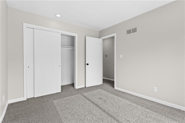 unfurnished bedroom featuring carpet flooring and a closet