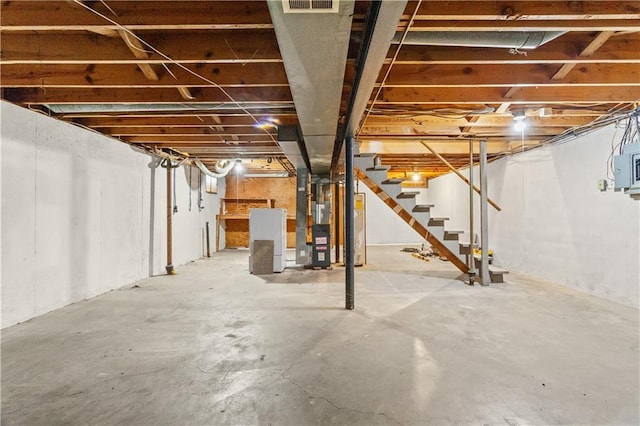 basement featuring heating unit and water heater