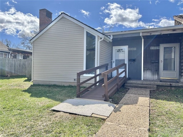 11331 Calico Dr, Kansas City, MO 64137 - property entrance featuring a chimney, fence, and a lawn