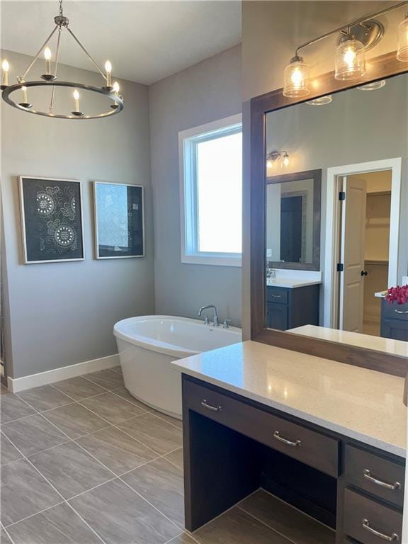 bathroom featuring vanity, a bathing tub, tile patterned floors, and a chandelier