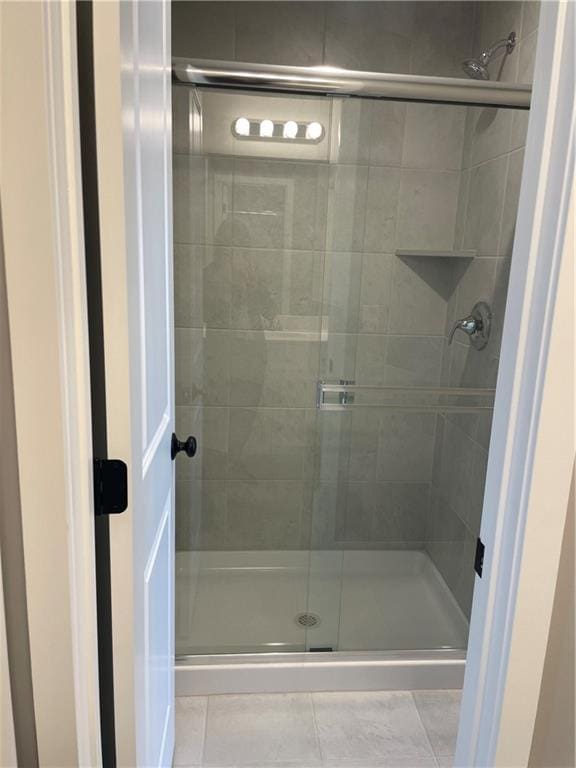 bathroom with tile patterned flooring and a shower with door