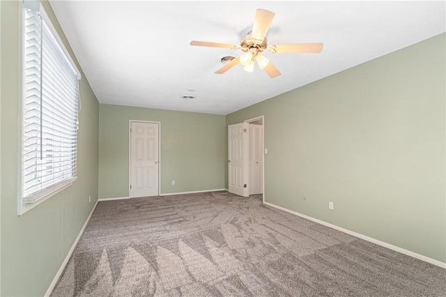 carpeted spare room featuring ceiling fan