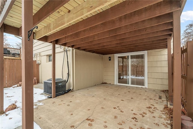 snow covered patio featuring central AC unit