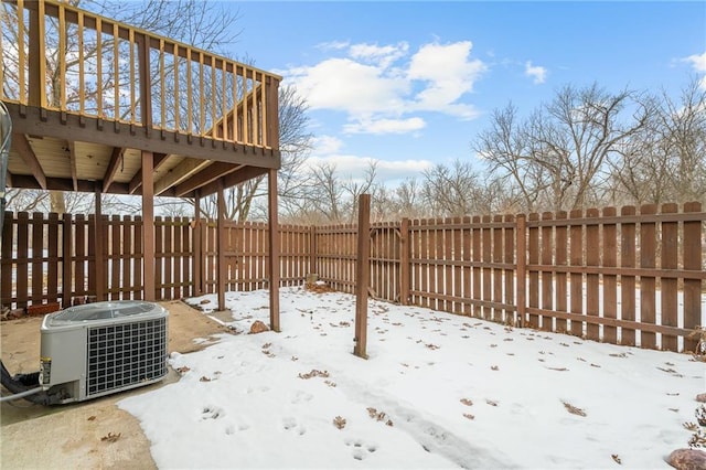 snow covered patio featuring central AC and a wooden deck