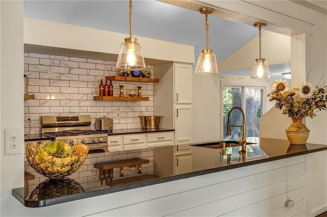 kitchen with white cabinetry, stainless steel gas stove, tasteful backsplash, and hanging light fixtures