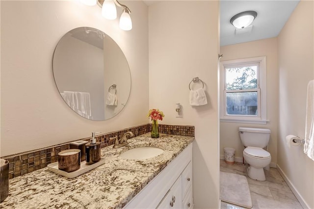 bathroom featuring toilet, backsplash, and vanity