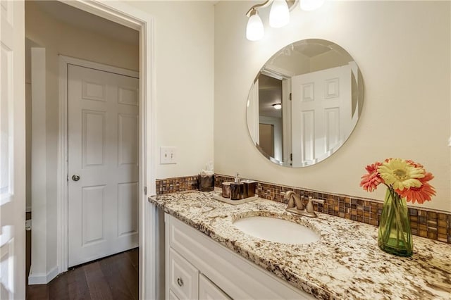 bathroom featuring tasteful backsplash, vanity, and hardwood / wood-style floors