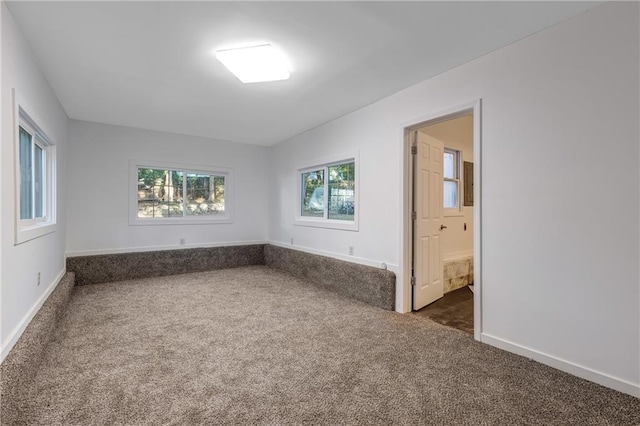 spare room with dark colored carpet