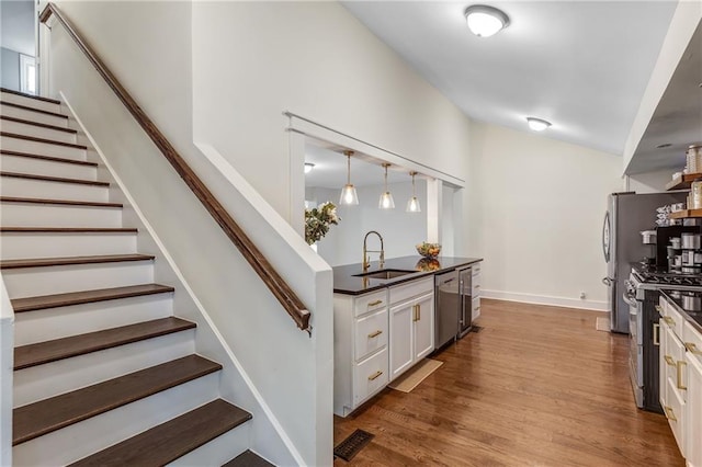 stairway featuring sink and hardwood / wood-style flooring