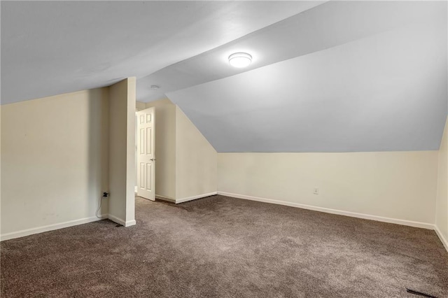 bonus room featuring vaulted ceiling and dark carpet