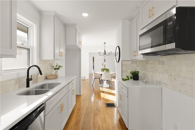 kitchen featuring stainless steel appliances, white cabinets, and sink