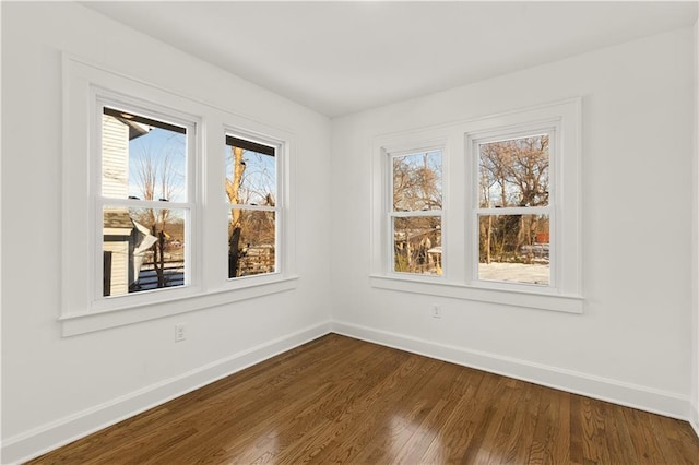 empty room featuring dark wood-type flooring and a wealth of natural light