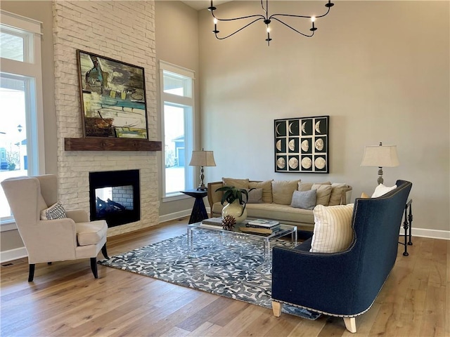 18337 Monrovia St, Overland Park, KS 66013 - living room with baseboards, wood finished floors, a multi sided fireplace, a chandelier, and a high ceiling