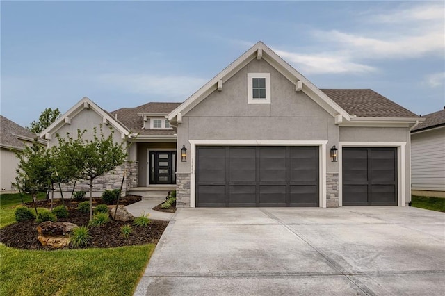 view of front of property with stone siding, driveway, an attached garage, and stucco siding