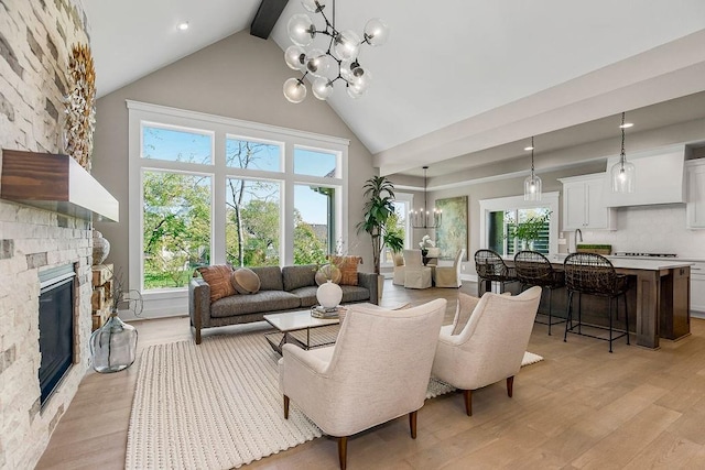 living room featuring beamed ceiling, high vaulted ceiling, an inviting chandelier, and light wood finished floors