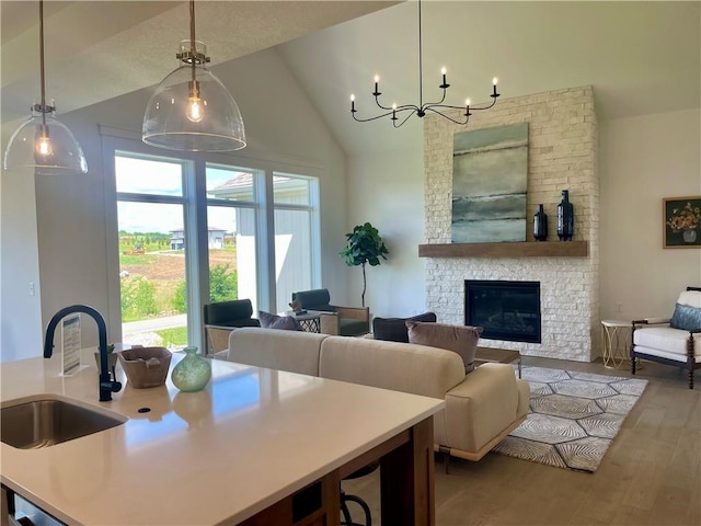 18300 Monrovia St, Overland Park, KS 66013 - kitchen featuring open floor plan, wood finished floors, a chandelier, hanging light fixtures, and high vaulted ceiling