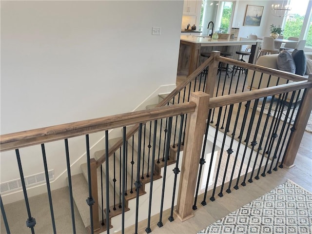 18300 Monrovia St, Overland Park, KS 66013 - stairs with wood finished floors and a chandelier