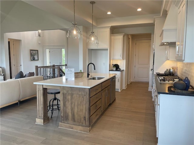 18300 Monrovia St, Overland Park, KS 66013 - kitchen featuring custom range hood, white cabinets, light wood-style floors, tasteful backsplash, and recessed lighting