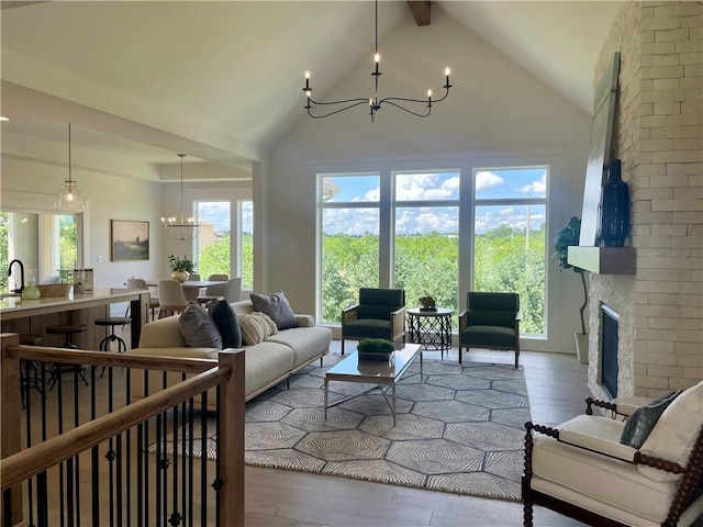 18300 Monrovia St, Overland Park, KS 66013 - living area featuring a chandelier, wood finished floors, beam ceiling, a large fireplace, and high vaulted ceiling