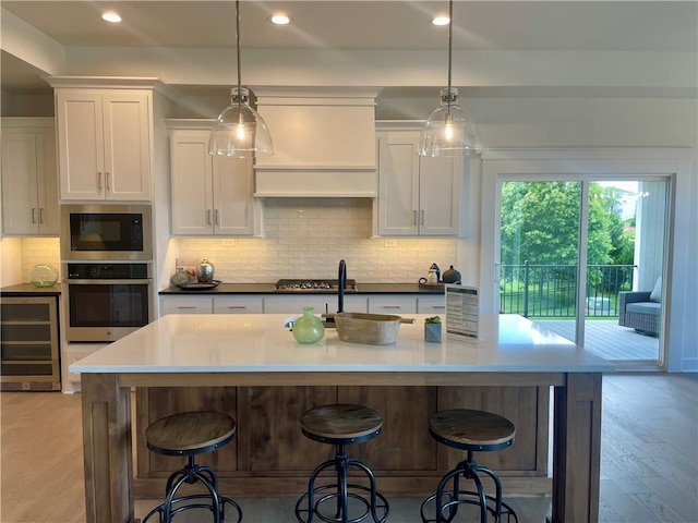 18300 Monrovia St, Overland Park, KS 66013 - kitchen with appliances with stainless steel finishes, wine cooler, white cabinetry, tasteful backsplash, and recessed lighting