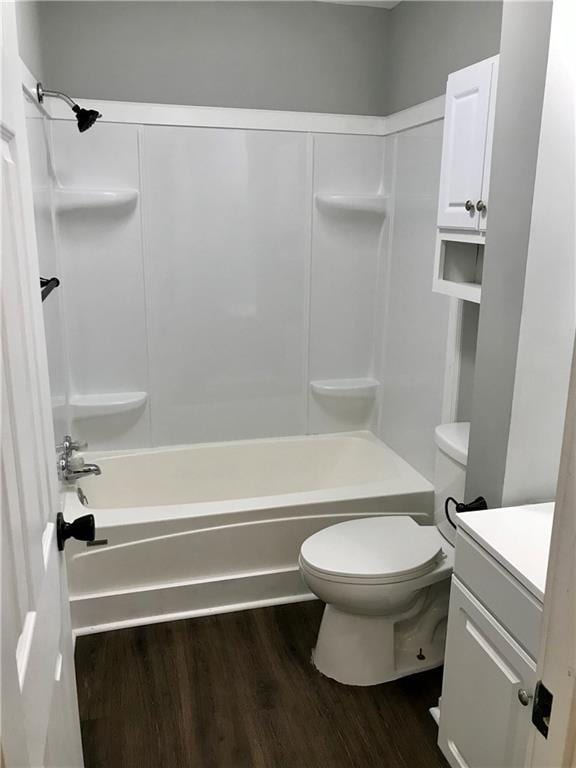 full bathroom featuring toilet, vanity, wood-type flooring, and bathing tub / shower combination